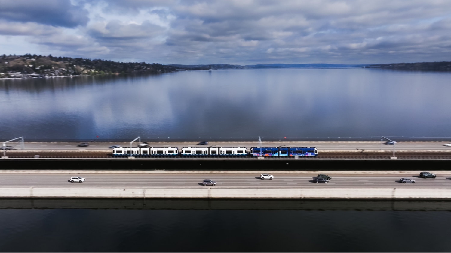 Sound Transit East Link Extension running next to cars across a bridge.