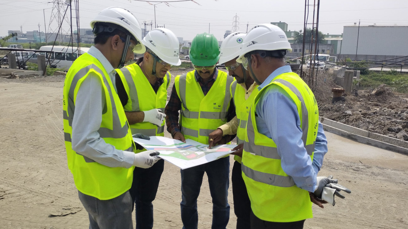 On-site engineers in hi-vis gatehered around a document.