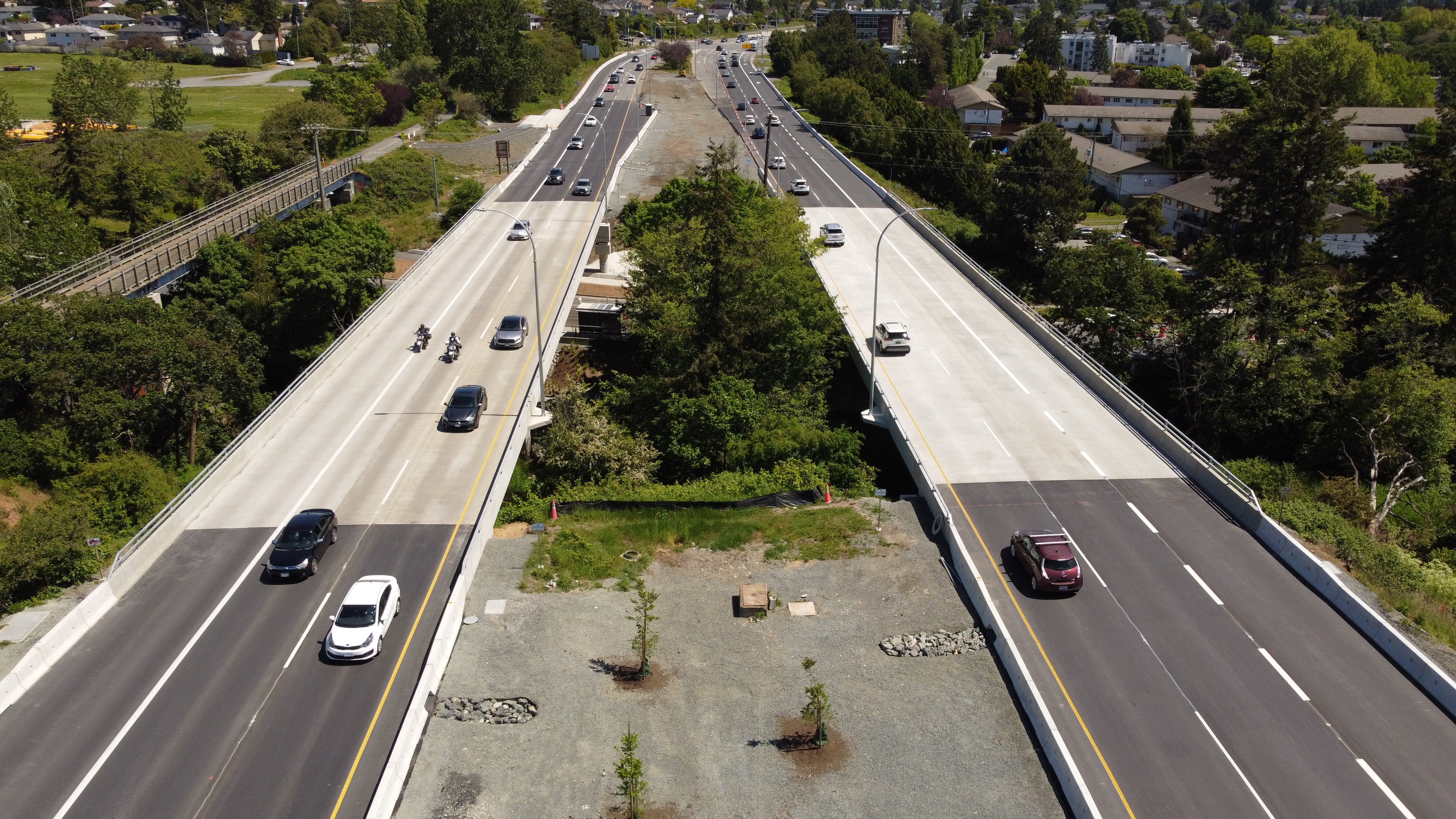 Highway 1 river bridge with cars driving on both sides and trees in the background