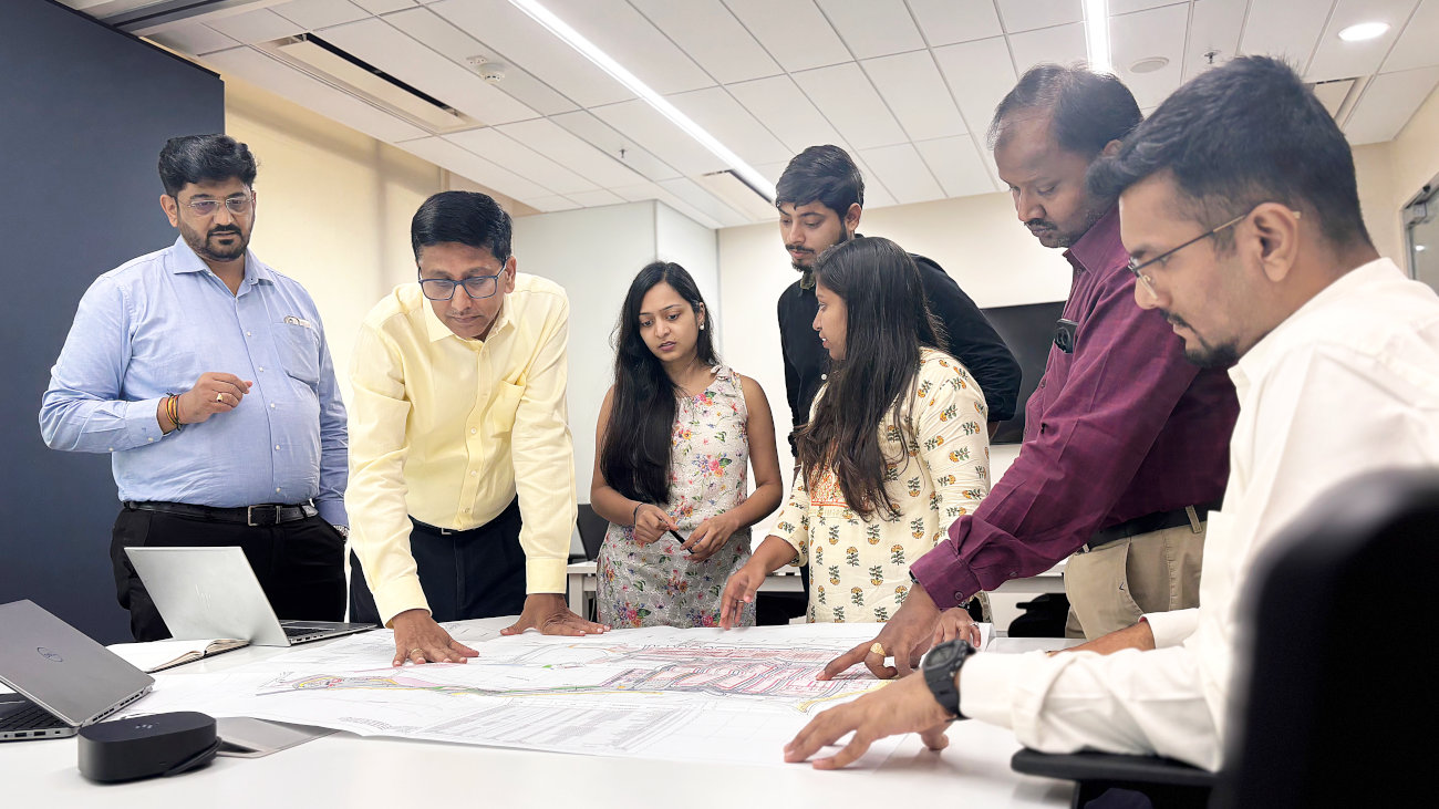Company staff looking at documents around a table.