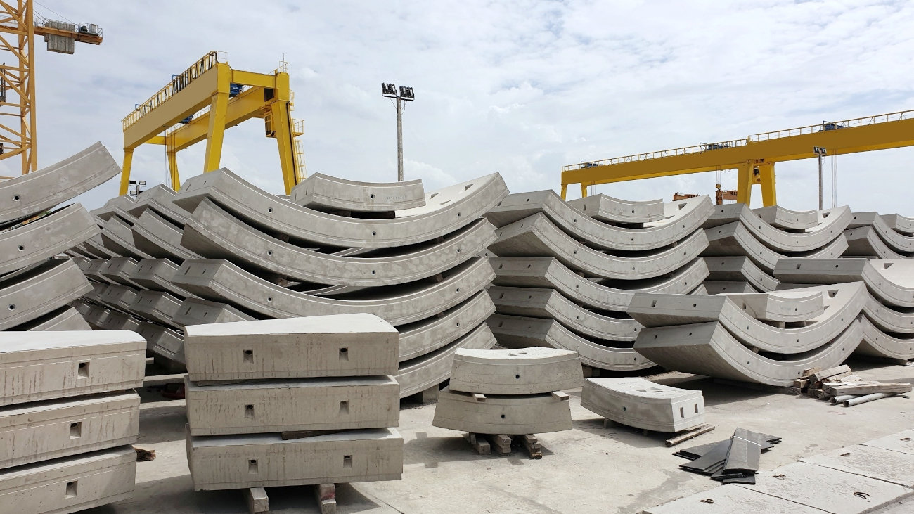 Piles of curved concrete sections on a work site.