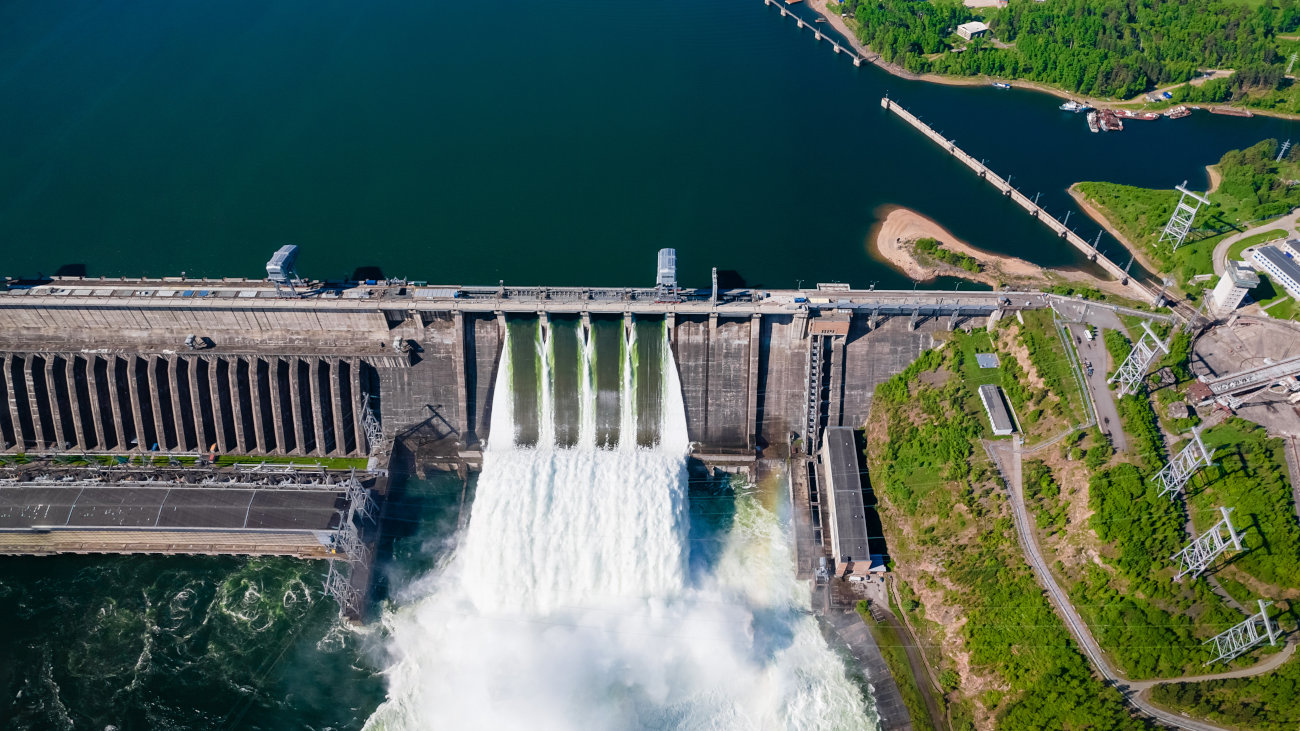Aerial shot of water rushing through a dam.