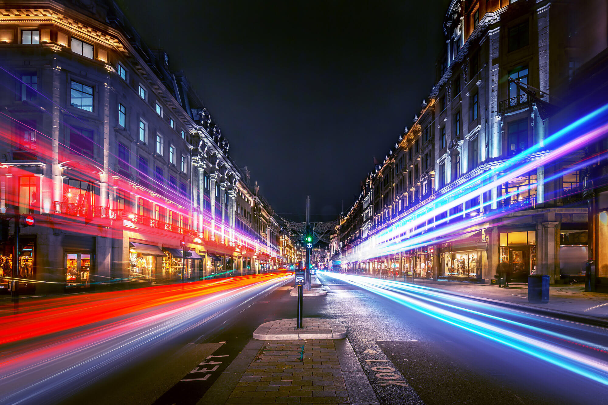 Long exposure shot of cars travelling along a street at night.