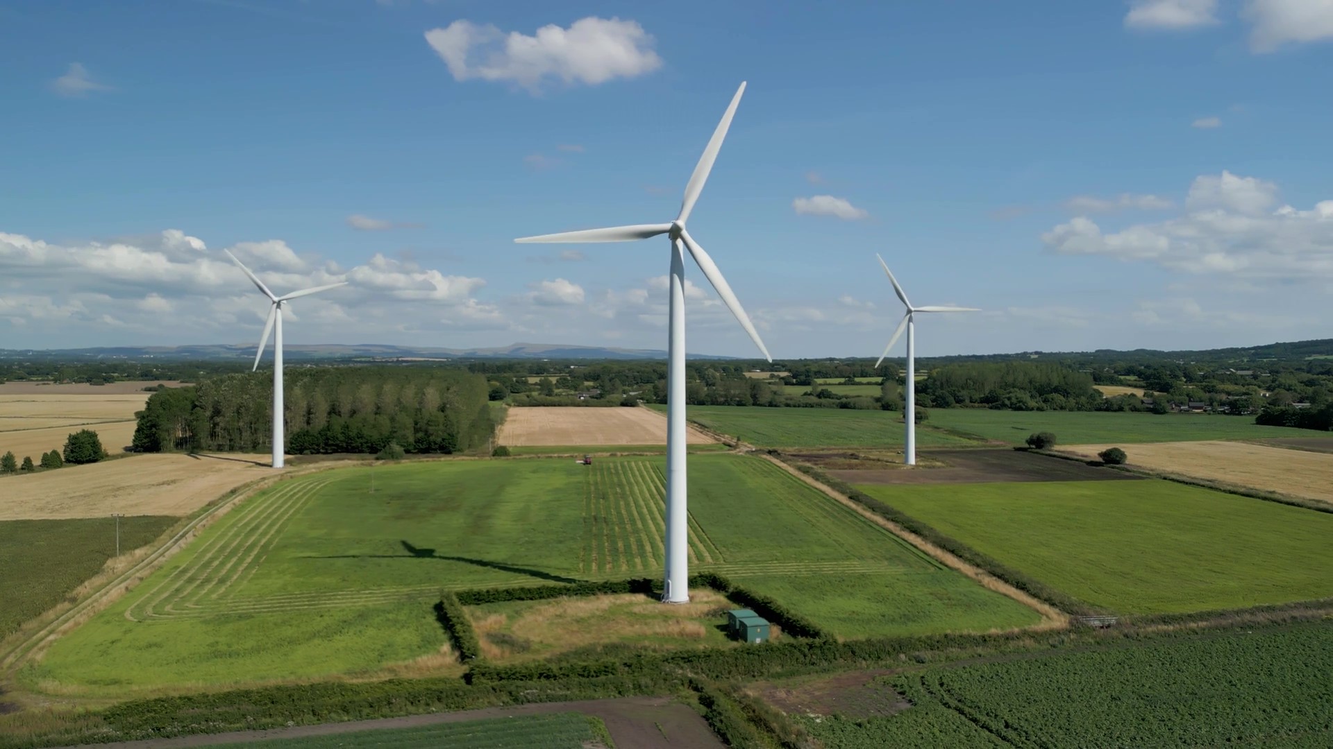 Three large wind turbines standing against a clear sky, symbolising renewable energy and innovation in sustainability—reflecting the focus on decarbonisation and efficient power solutions discussed at Carbon Crunch 2025.