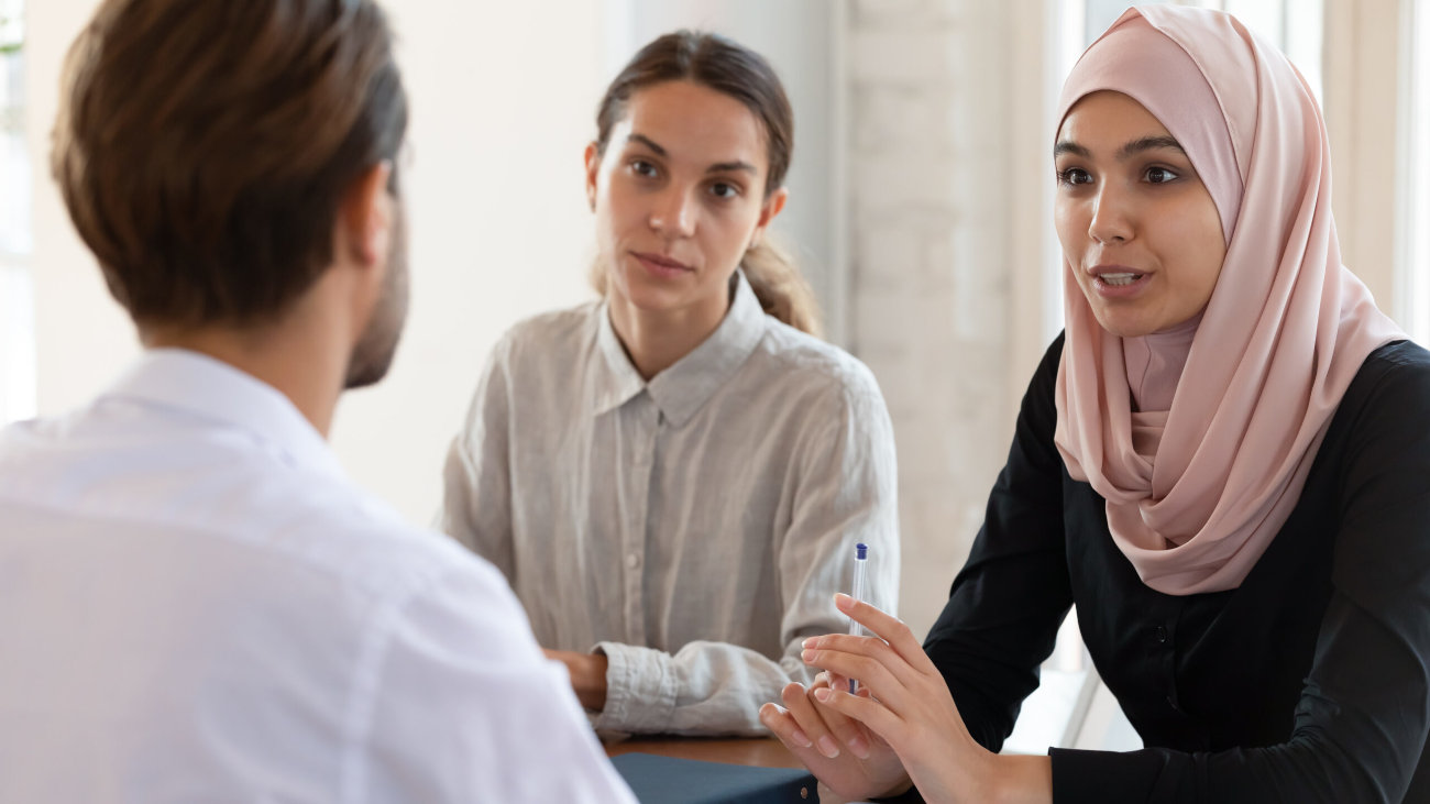 Three people having a business meeting at a table.