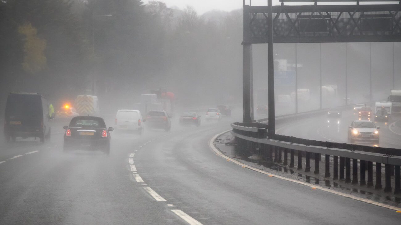Cars driving on a motorway in the rain.