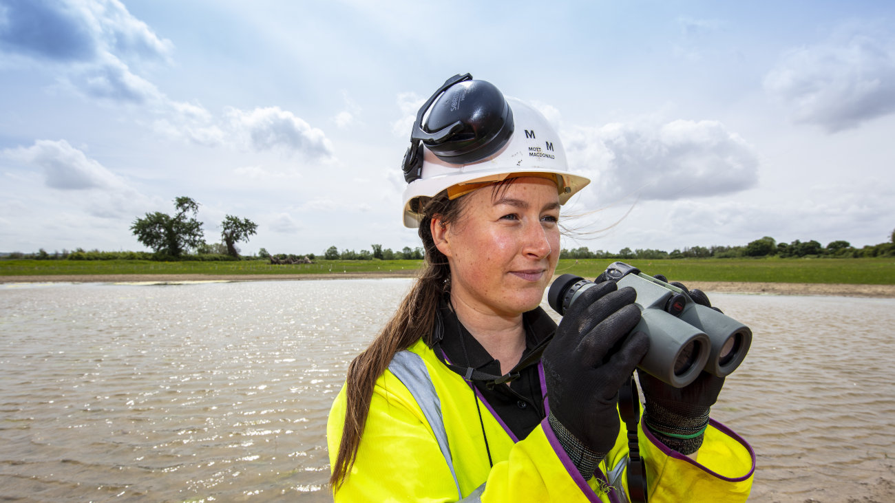 Female engineer holding binoculars.