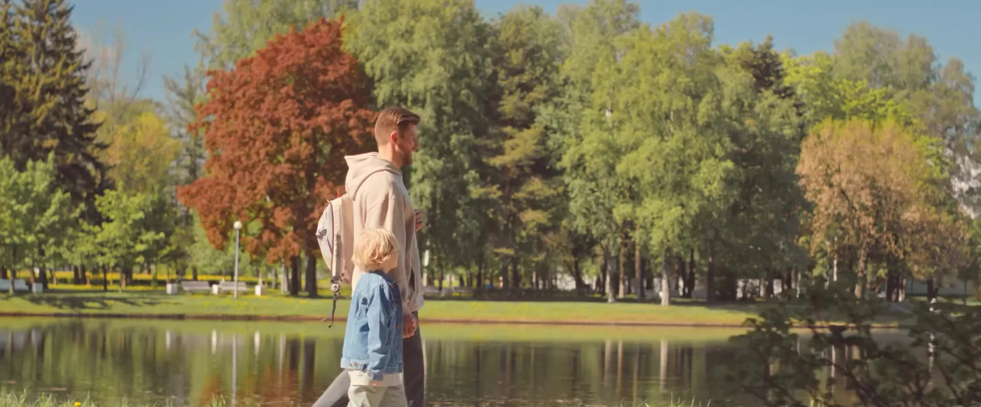 A father and son walking by a lake.