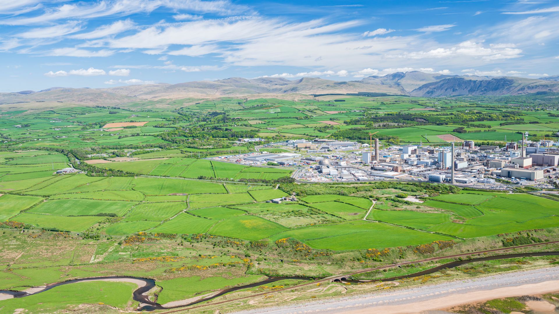 Aerial view of the Sellafield site in Cumbria, surrounded by green fields, coastline and rural landscape, supporting coverage of the Pioneer Park clean‑energy development.