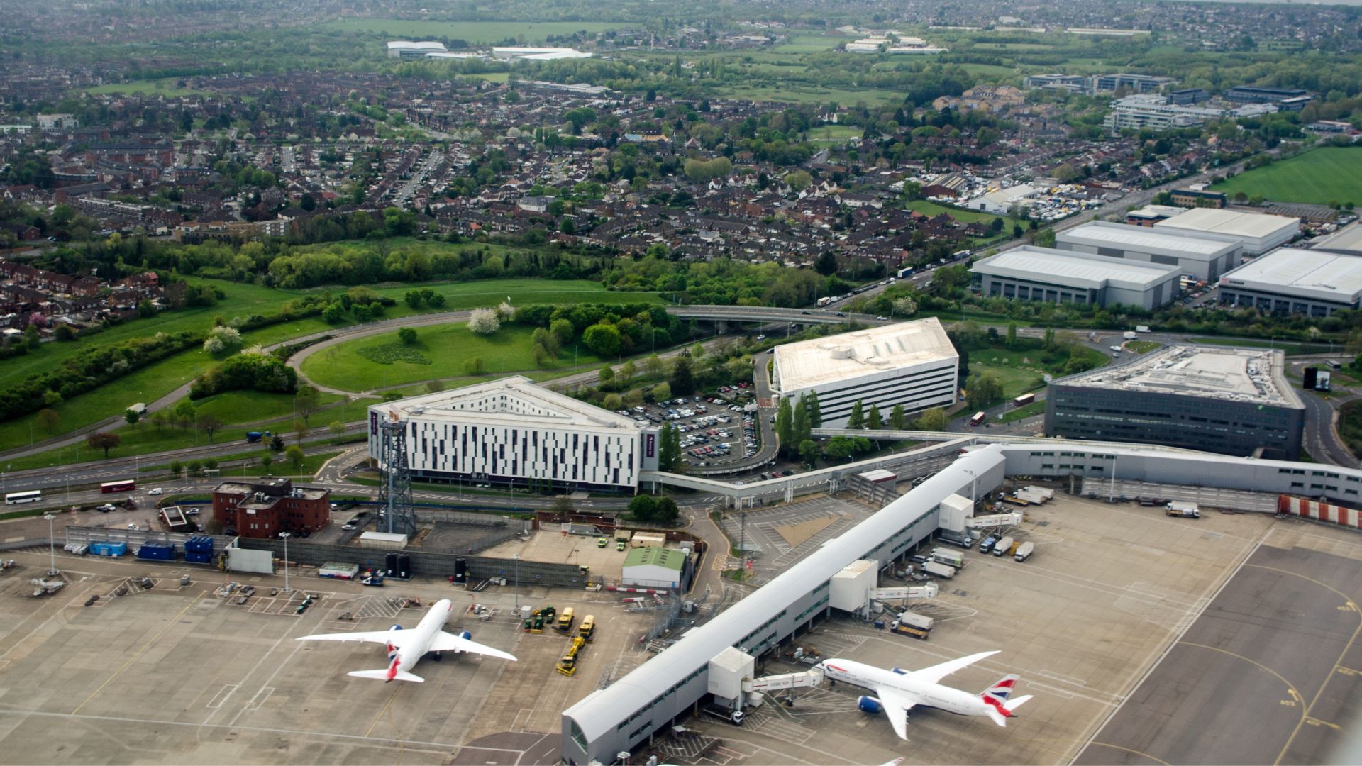 Aerial view of two British Airways aircraft at Heathrow Airport, illustrating the scale of operations and the challenge of achieving zero-emission airports in England.