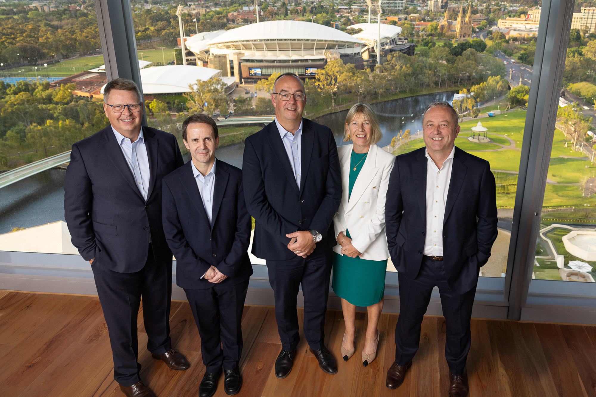 The Mott MacDonald exective board stood in front of a window with a stadium in the background.