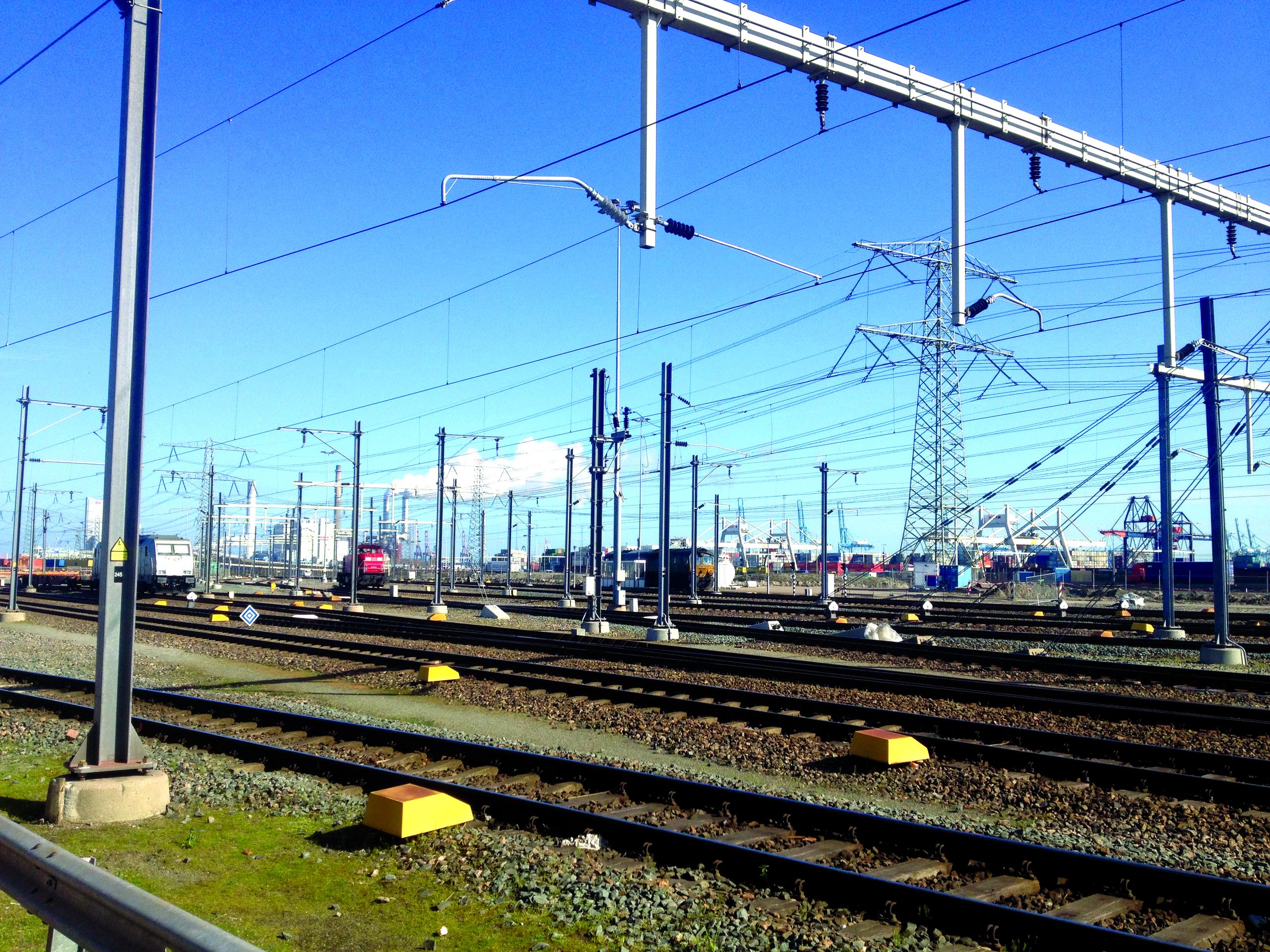 Overhead lines above railway tracks on a sunny day.