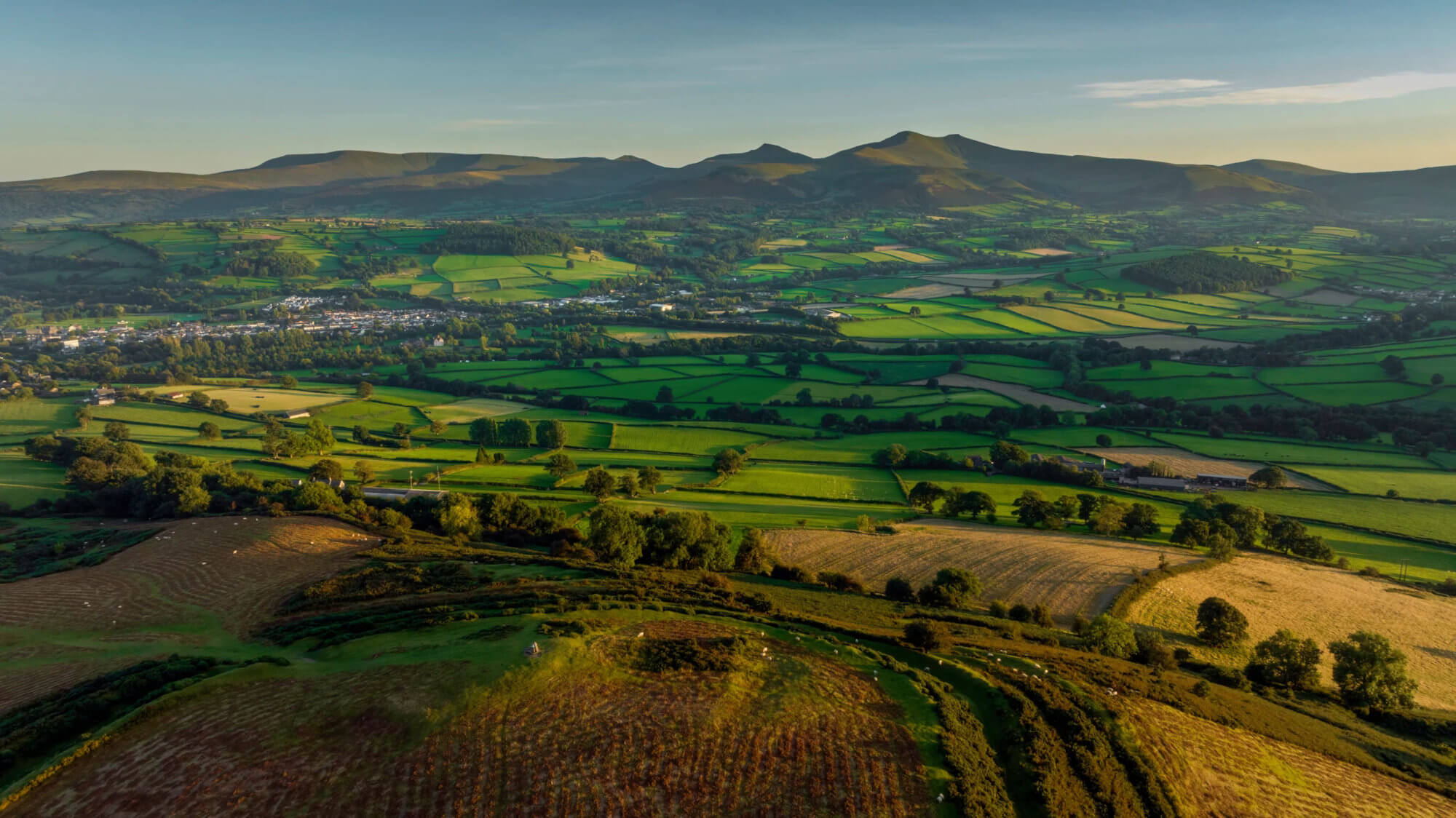 Green fields with hills in background.