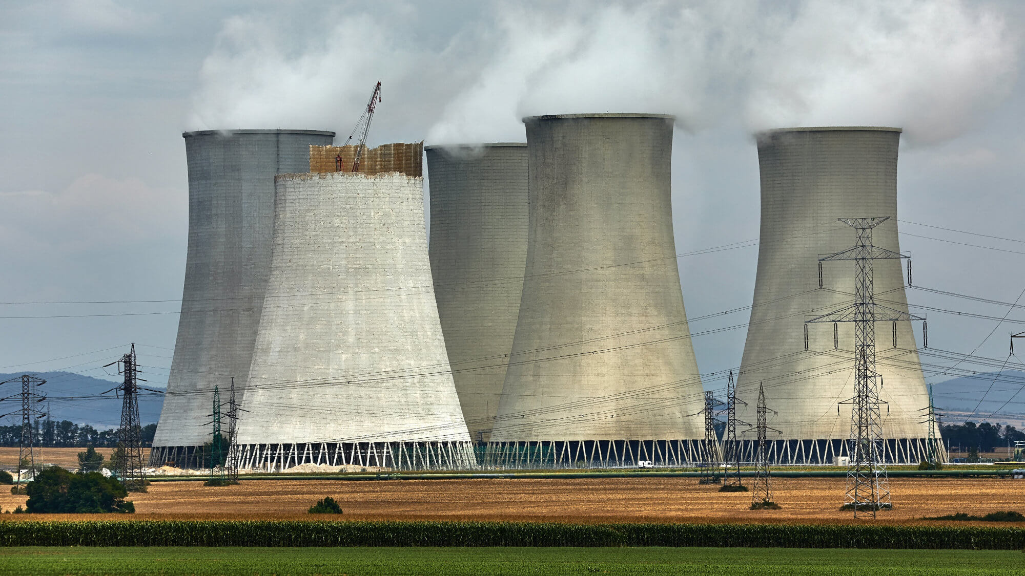 Nuclear station cooling towers emitting plumes of steam.