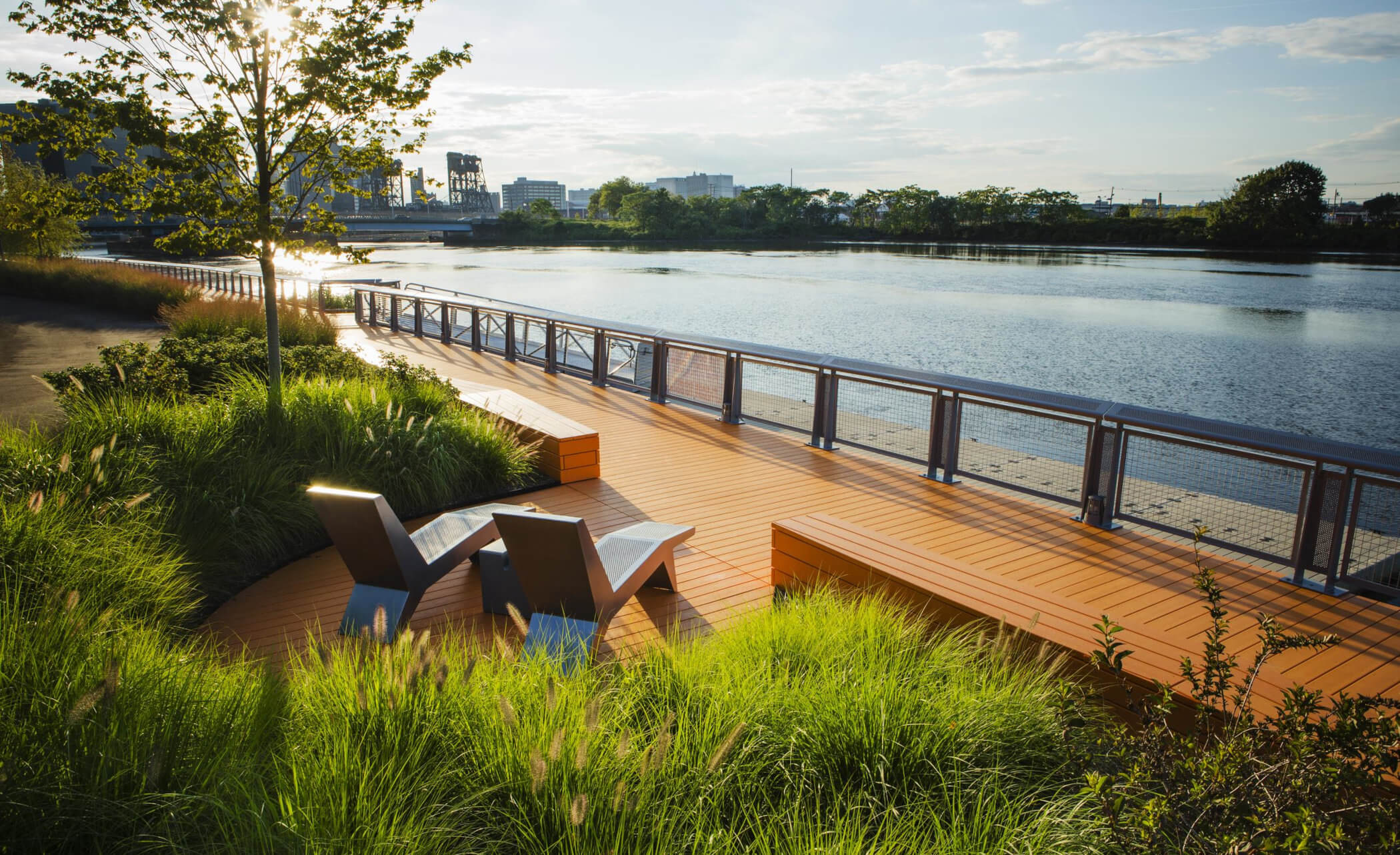 Greenery and orange decking alongside a river in New Jersey.