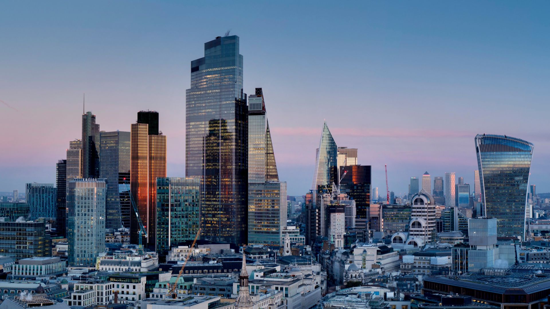 London City skyline at dusk featuring modern skyscrapers and major commercial buildings, illustrating large‑scale building development and coordinated urban planning.