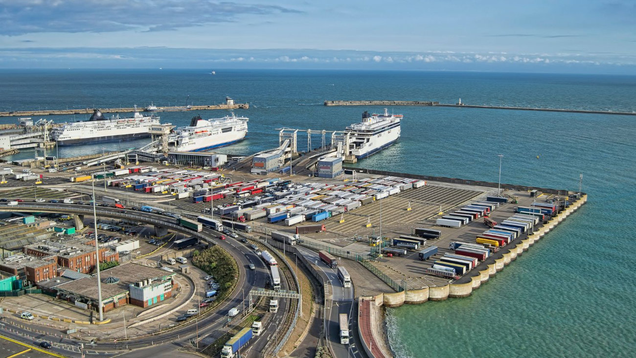 An aerial view of the Port of Dover on a clear day, with road vehicles and large boats in shot