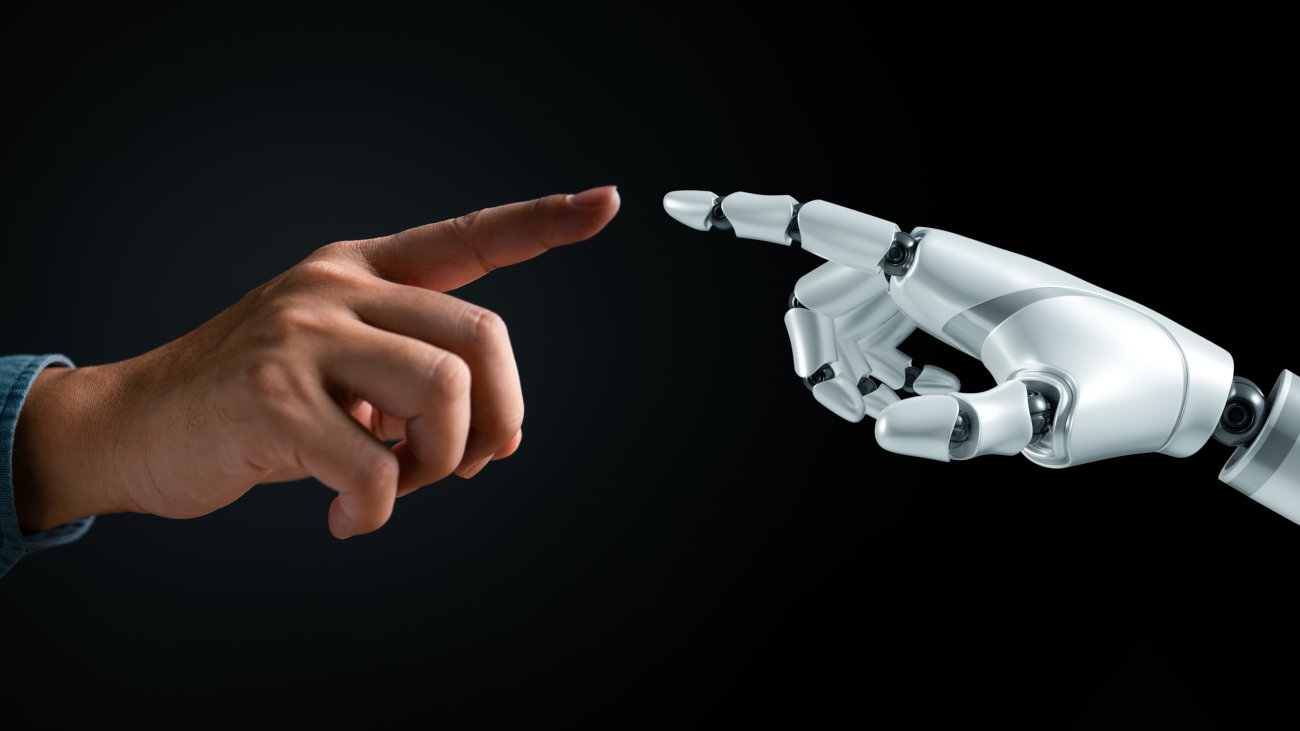 A human hand and robot hand.