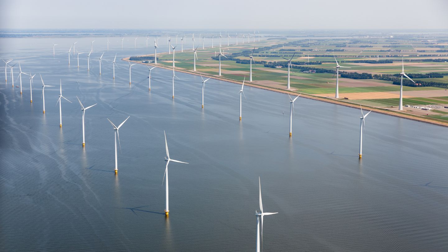 Aerial view of offshore wind turbines along the Dutch coastline, symbolising renewable energy sources like wind and solar, and their role in hydrogen-powered decarbonisation for achieving net zero.