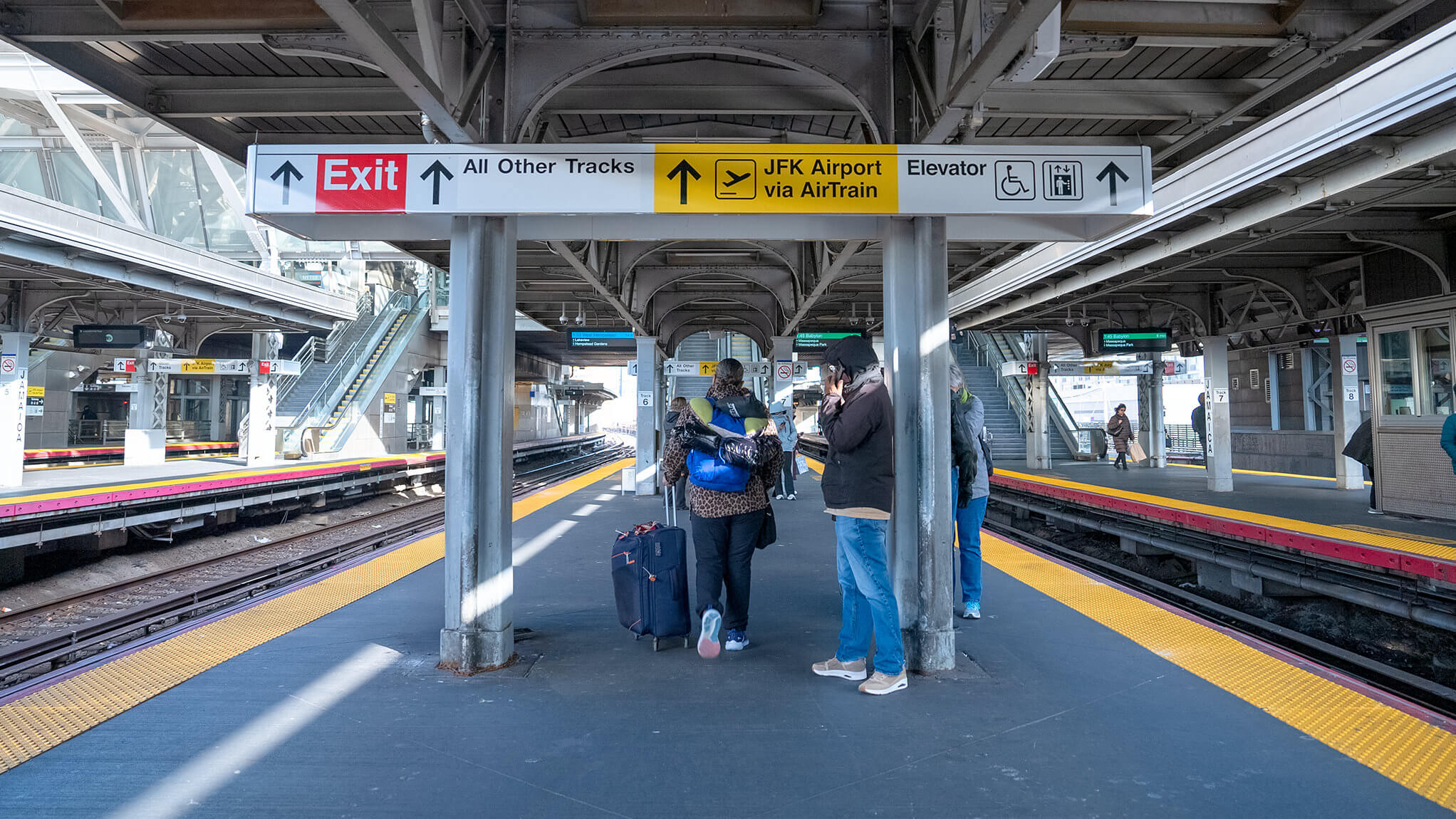 People standing on an NYC subway platform.